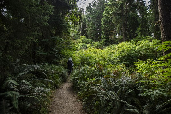 Woman walking on path in forest