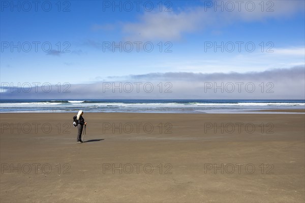 Woman standing on sandy beach and looking at view