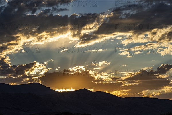 Silhouette of mountains with sunrise in background