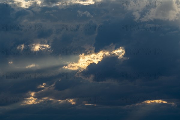 Sunlight shining through dark clouds at sunset