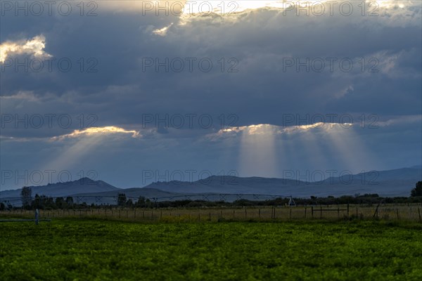 Sunlight shining through dark clouds at sunset