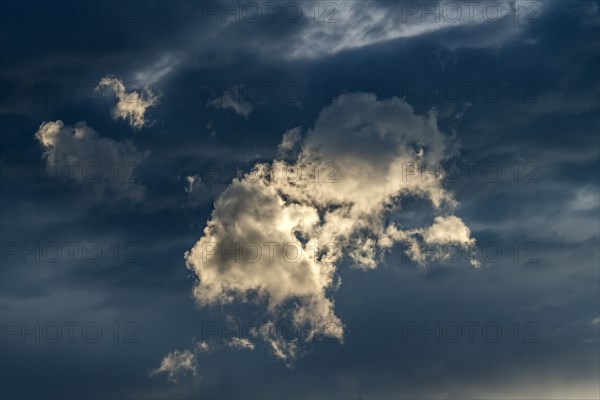 Sunlight illuminating cloud in dark sky at sunset