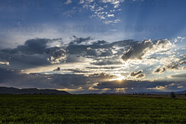 Cloudy sunset sky over rural landscape