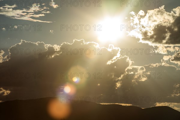 Lens flare from afternoon sun and clouds in sky