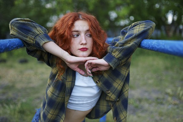 Redhaired woman posing at playground