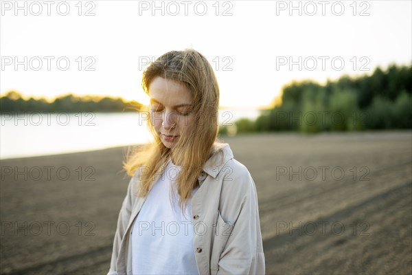 Portrait of woman standing on beach at sunset