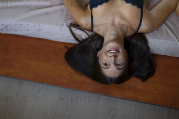 Directly above view of smiling woman lying on bed