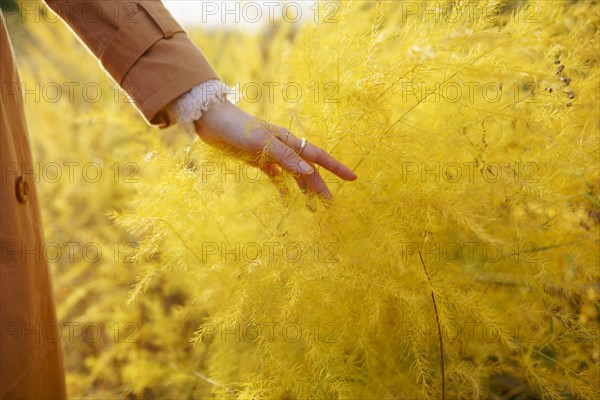 Woman in trench coat touching crop