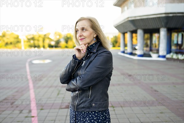 Portrait of thoughtful woman standing in front of building