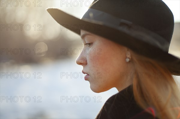 Portrait of young woman in hat on sunny day