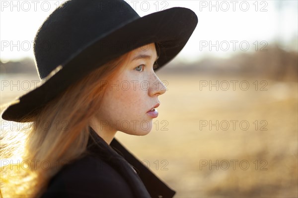 Portrait of young woman in hat on sunny day