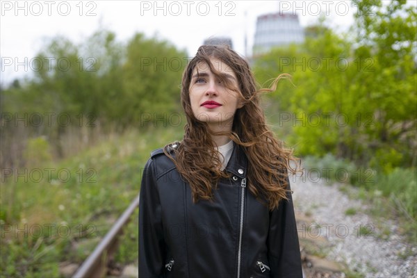 Portrait of woman standing on railroad track