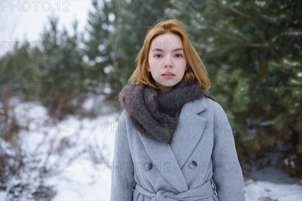 Portrait of young woman standing in snowy landscape