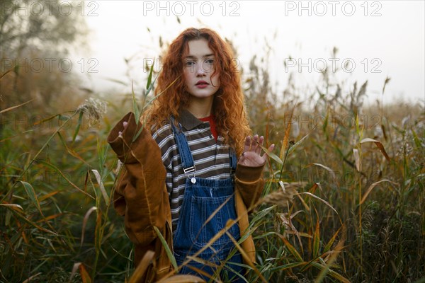 Portrait of serious woman walking in field at dawn