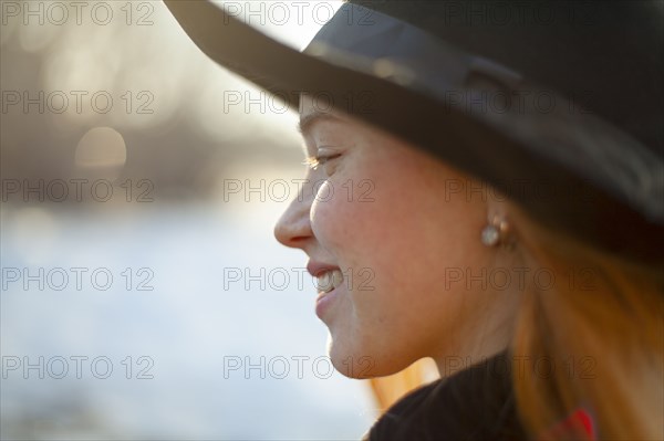 Portrait of smiling woman in hat at sunset