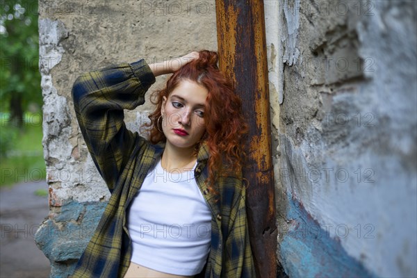 Portrait of thoughtful woman leaning on building wall