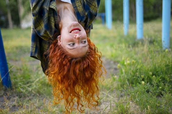 Upside down portrait of redhead woman looking away