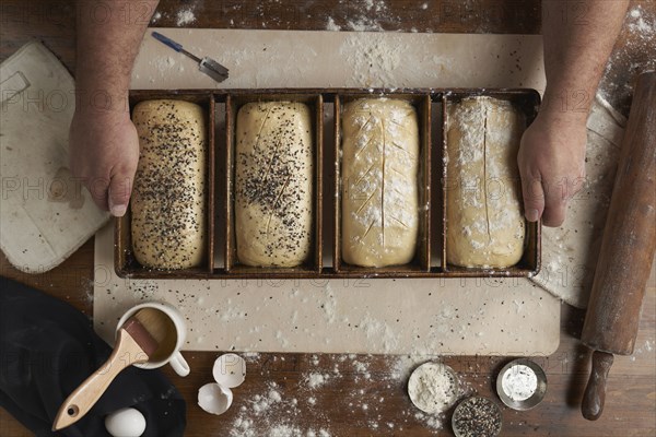 Directly above view of baker preparing bread in kitchen