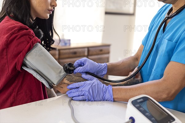 Nurse measuring blood pressure to female patient