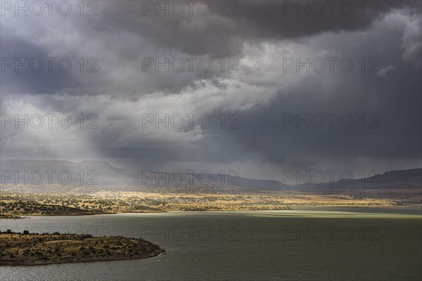 Usa, New Mexico, Abiquiu, Sun shining through storm clouds over Abiquiu Lake