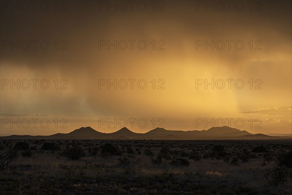 Usa, New Mexico, Santa Fe, Storm and rain over Cerrillos Hills at sunset