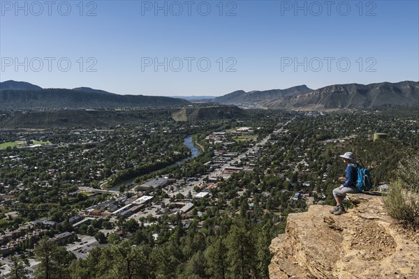 Usa, Colorado, Durango, Woman sitting on ledge in San Juan Mountains