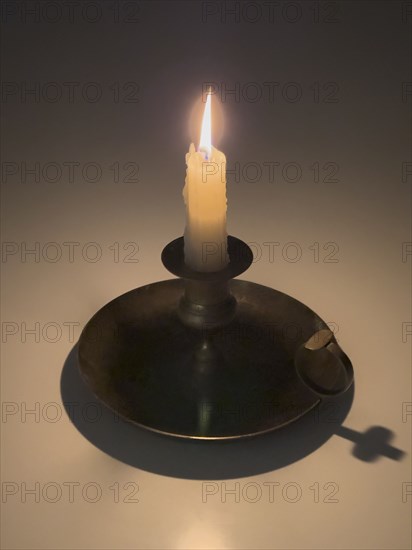 Studio shot of candle in candlestick holder