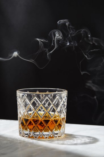 Smoke above glass of whiskey
