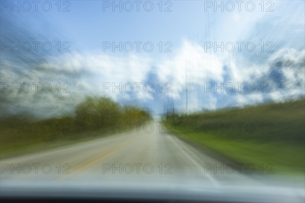 USA, Wisconsin, Country road and clouds seen from moving car