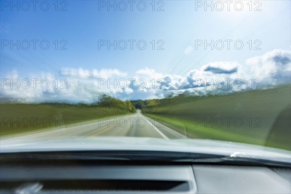 USA, Wisconsin, Country road and clouds seen from moving car