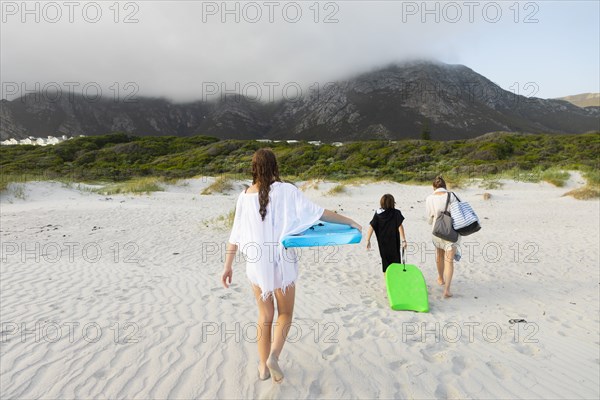 South Africa, Hermanus, Rear view of family walking on beach