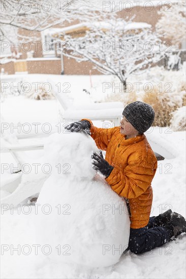 Boy building snowman