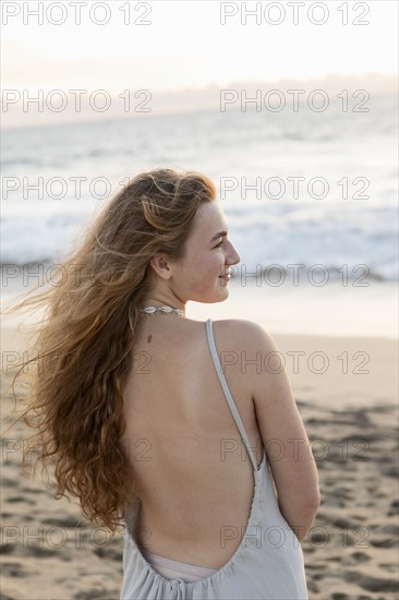 Mexico, Baja, Pescadero, Rear view of teenage girl on beach at sunset