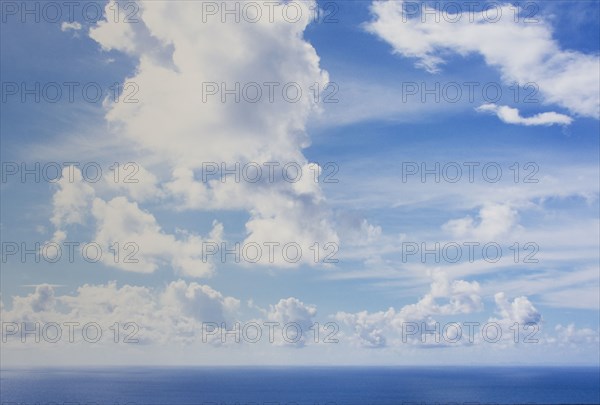 White puffy clouds above calm sea