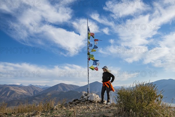 Female hiker atop Carbonate Mountain at prayer flags pole
