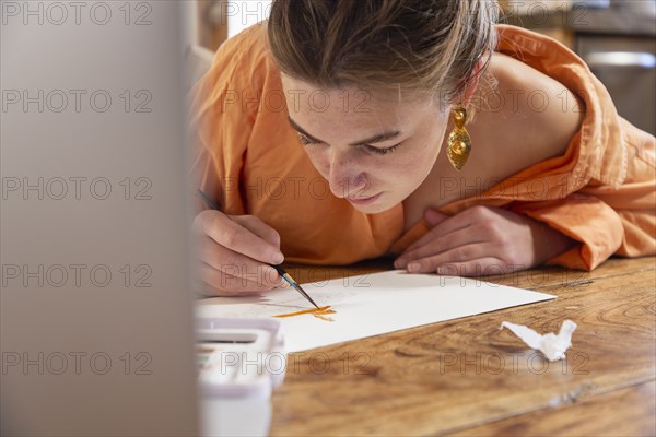 Teenage girl painting with watercolors at table