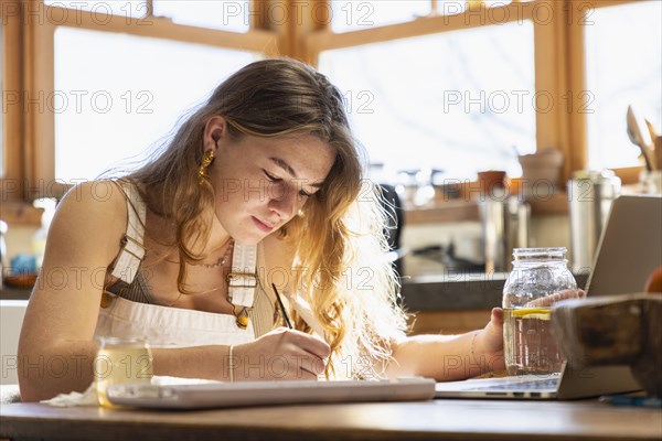 Teenage girl painting with watercolors at table