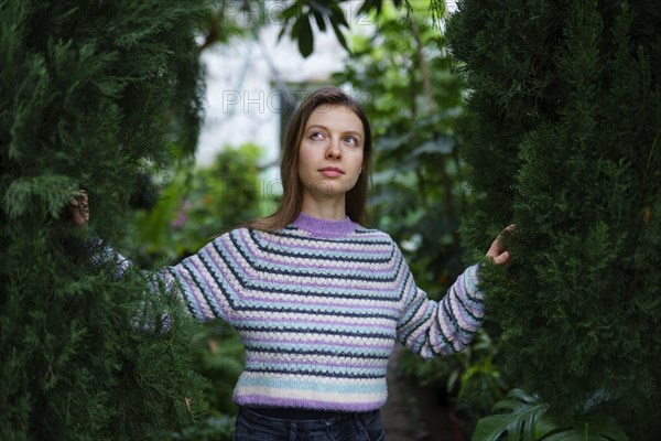 Portrait of woman standing in greenhouse