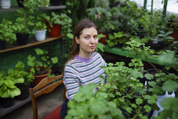 Portrait of woman standing in greenhouse