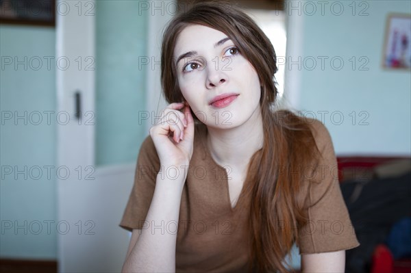 Portrait of pensive woman in living room