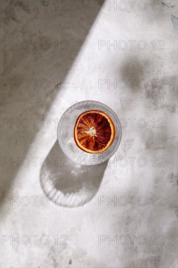 Overhead view of glass of Tequila with blood orange slice on marble surface, New York, New York, USA