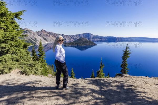USA, Oregon, Portrait of smiling woman near calm Crater lake