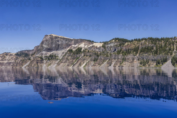 USA, Oregon, Cliffs reflected in calm surface of Crater lake