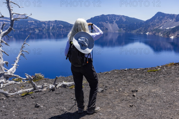 USA, Oregon, Crater Lake, Rear view of woman facing calm Crater lake