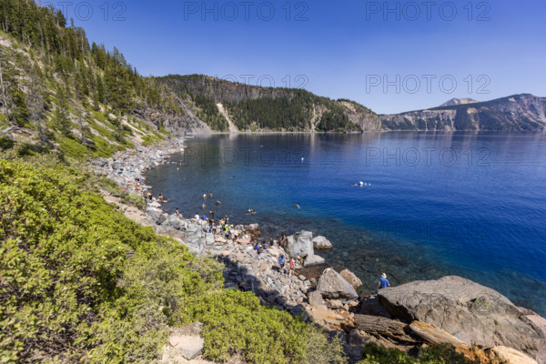 USA, Oregon, People relaxing by calm Crater lake