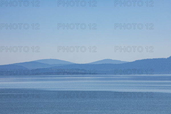 USA, Oregon, Klamath Falls, Clear blue sky and hills by calm Kiamath Lake