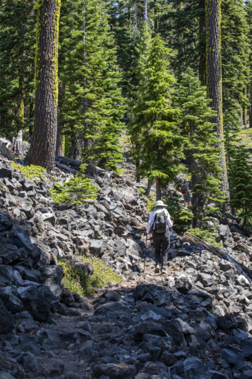 USA, Oregon, Crater Lake, Rear view of female hiker on rocky trail