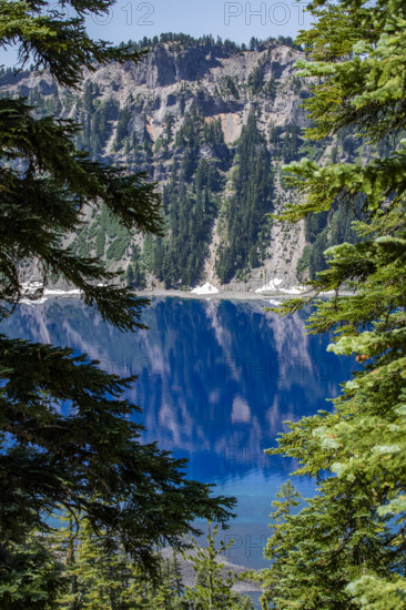 USA, Oregon, Cliffs reflected in calm surface of Crater lake