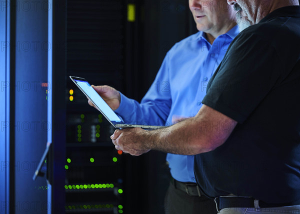 Workers looking at laptop in data center