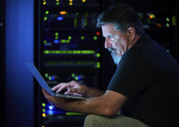 Man using laptop in data center